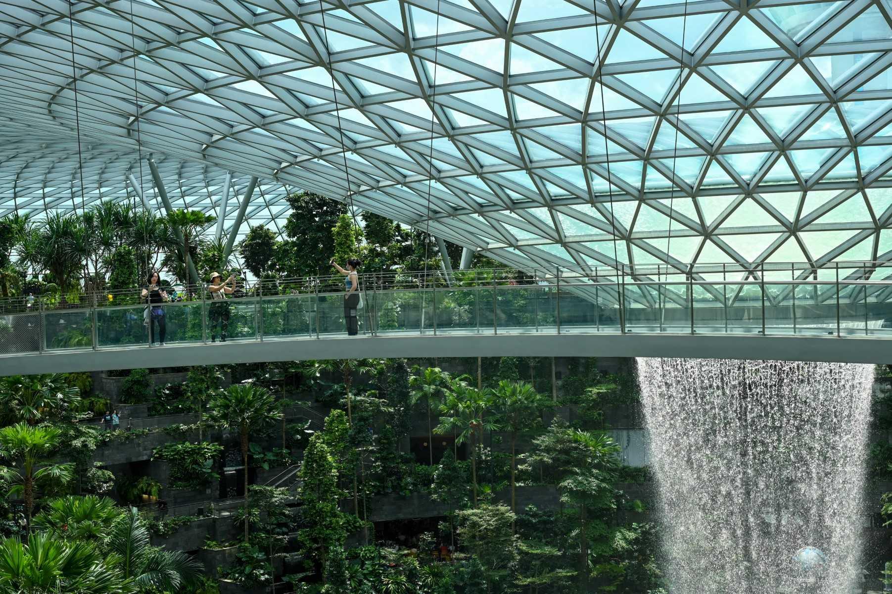 People take picture from a observation bridge of Rain Vortex at Jewel Changi airport in Singapore on Dec 7, 2022. Photo: AFP