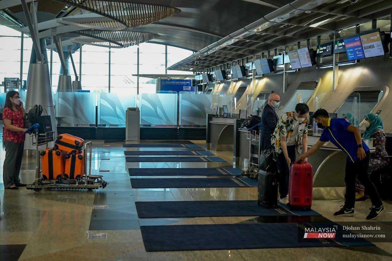 Gambar fail pelawat dari luar negara menunggu giliran di kaunter KLIA, Sepang.