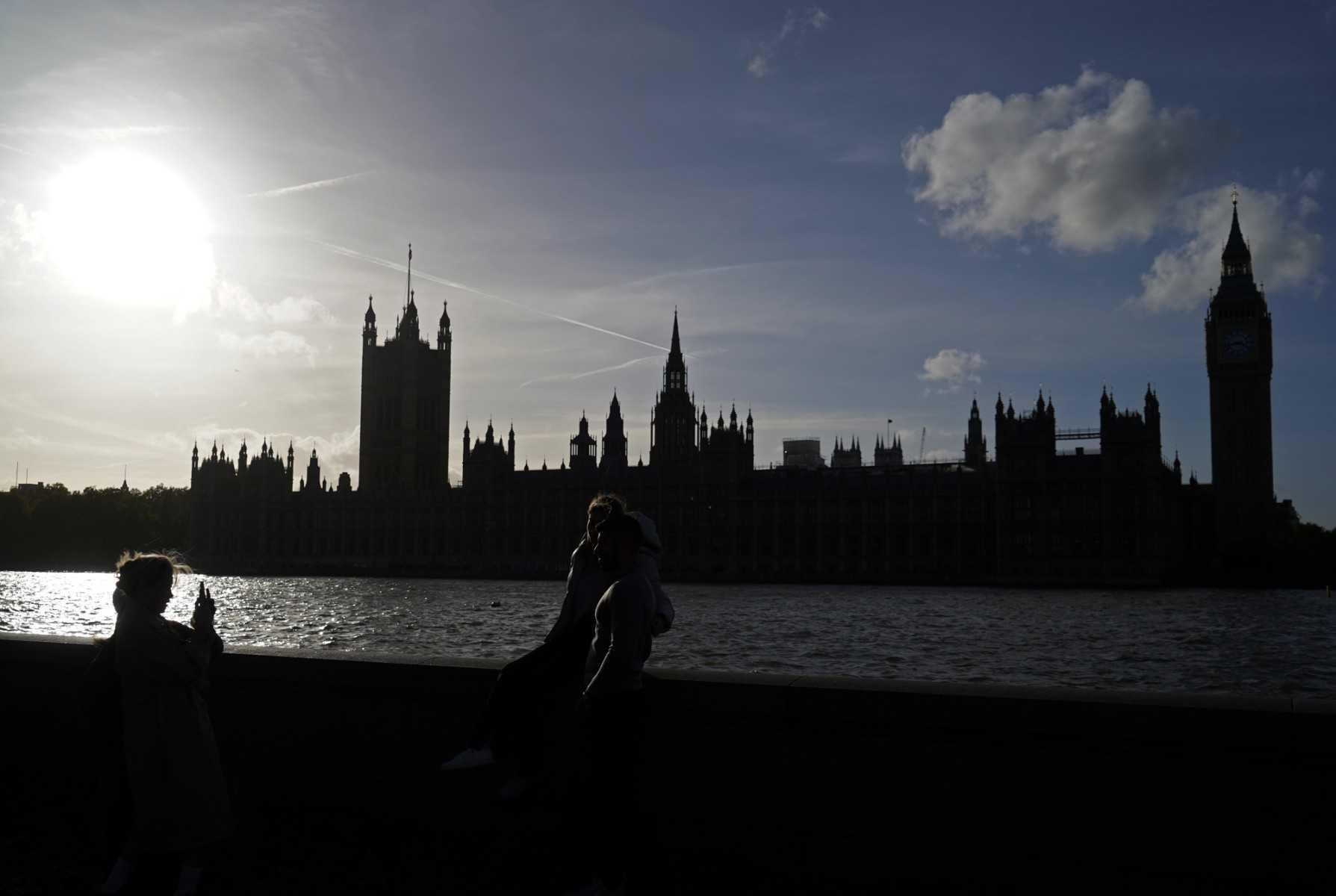 People pose for a photograph on the banks of the River Thames in London on Oct 26, 2022. Photo: AFP
