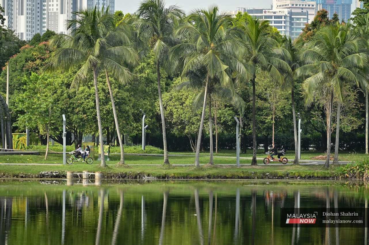 People cycle near the lake at Taman Tasik Titiwangsa in Kuala Lumpur.