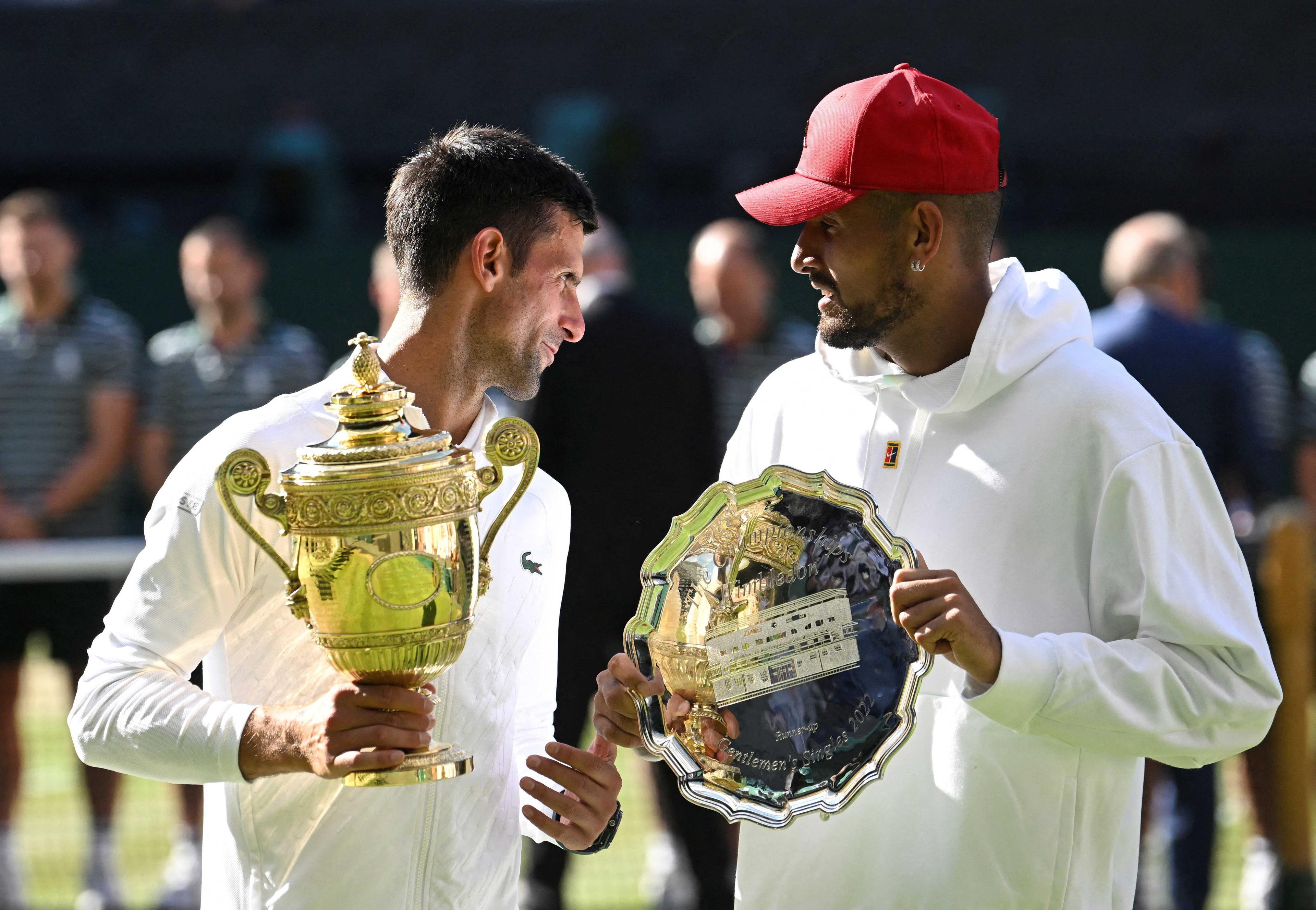 Serbia's Novak Djokovic poses with the trophy after winning the Wimbledon men's singles final alongside runner up Australia's Nick Kyrgios, July 2022. Photo: Reuters