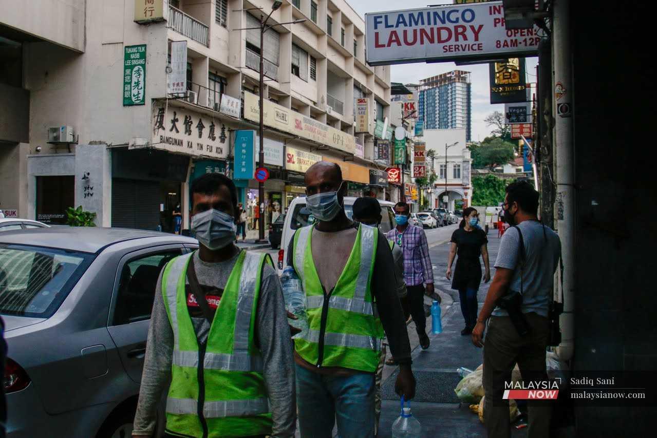 Foreign workers head home from work at Petaling Street in the capital city of Kuala Lumpur.
