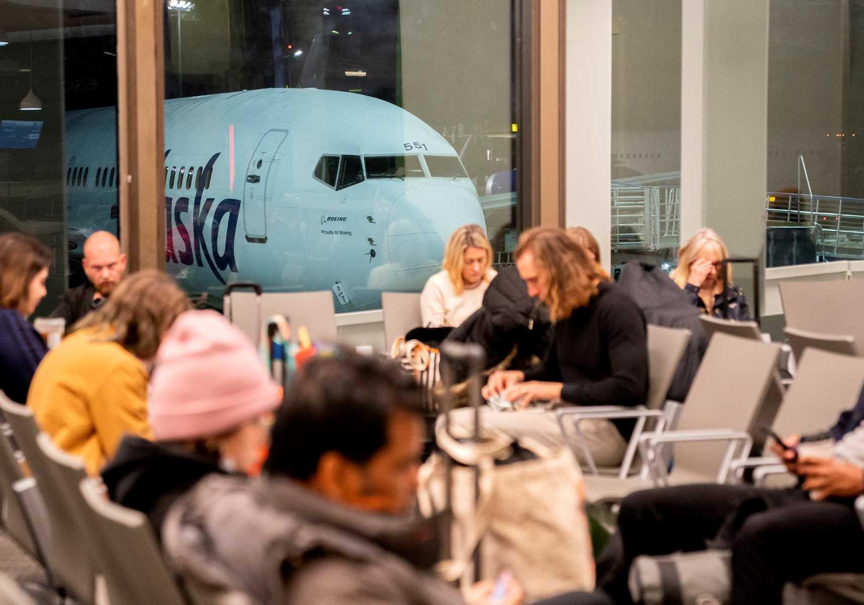 Travellers wait in the terminal as an Alaska Airlines plane sits at a gate at Los Angeles International Airport in Los Angeles, on Jan 11. Photo: AFP