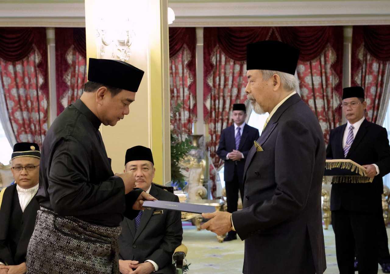 Sabah governor Juhar Mahiruddin (second right) presents the letter of appointment to Sugut assemblyman James Ratib at Istana Seri Kinabalu in Kota Kinabalu today. Photo: Bernama
