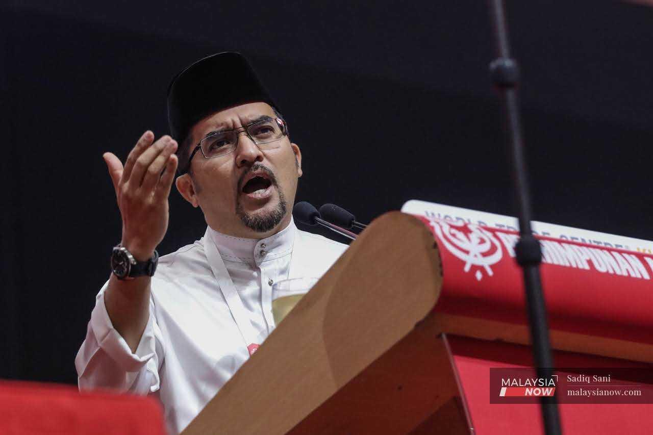 Umno Youth chief Asyraf Wajdi Dusuki speaks during the party's 2022 general assembly at the World Trade Centre in Kuala Lumpur on Jan 12. 

