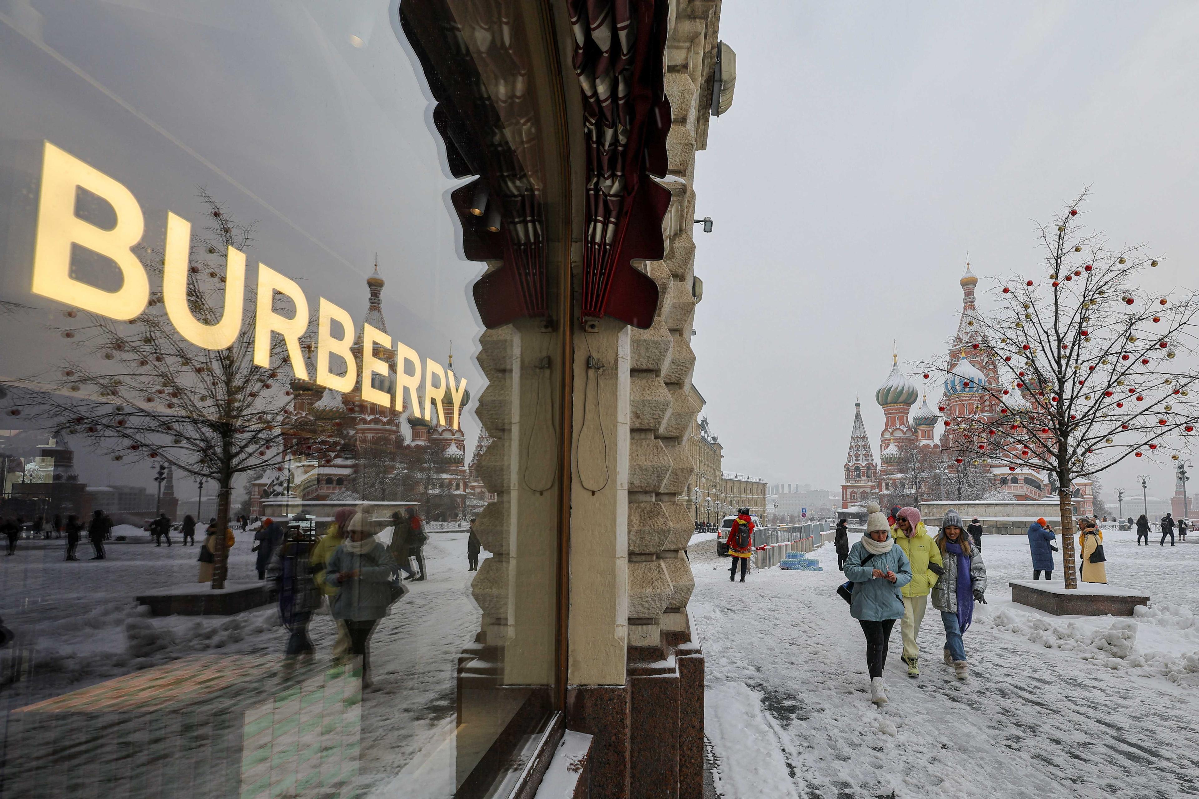 People walk past a closed boutique in the Red Square, during snowfall in Moscow, Russia Dec 14, 2022. Photo: Reuters