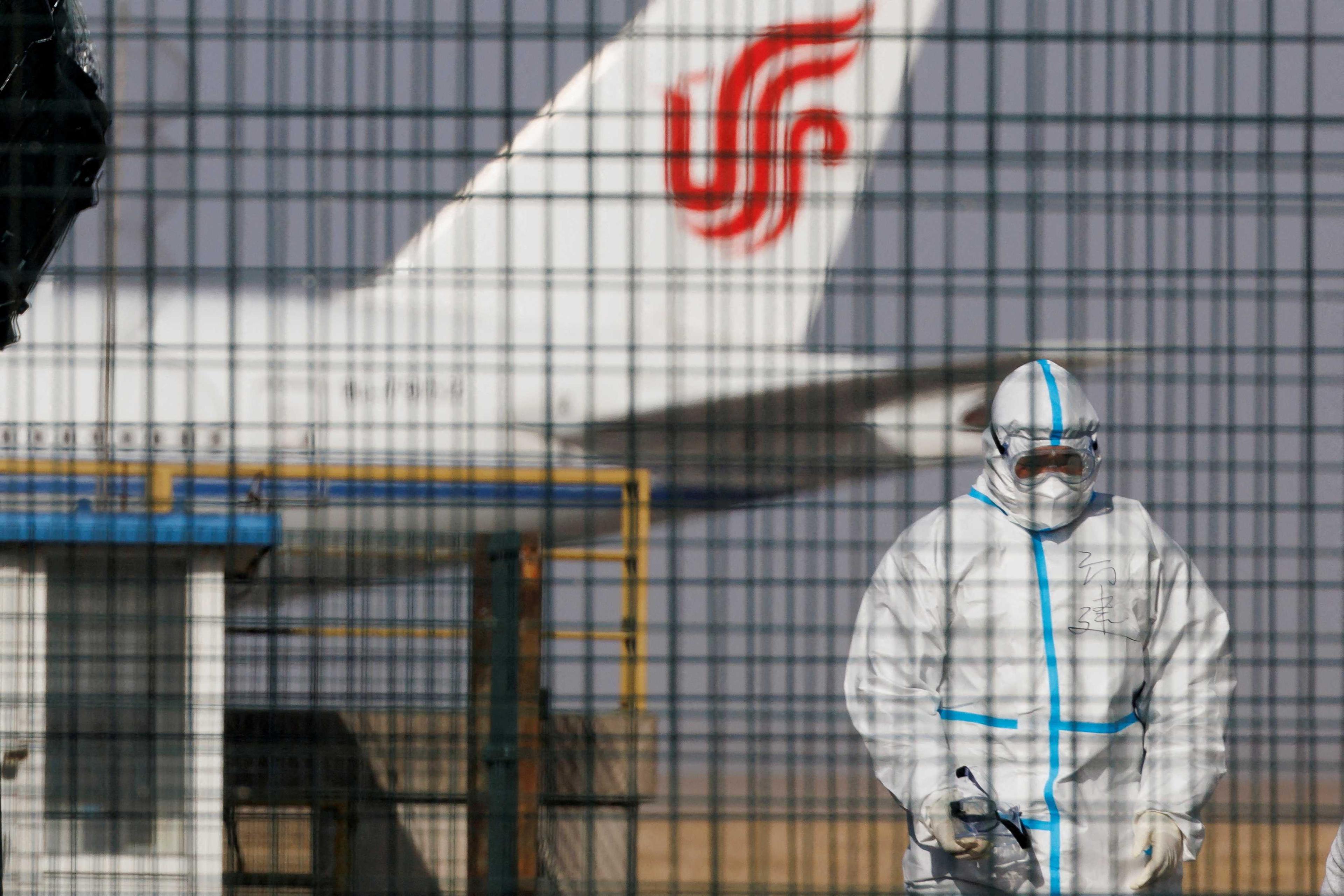 A worker in a protective suit walks near a plane of Air China airlines at Beijing Capital International Airport as Covid-19 outbreaks continue in Beijing, China Jan 6. Photo: Reuters