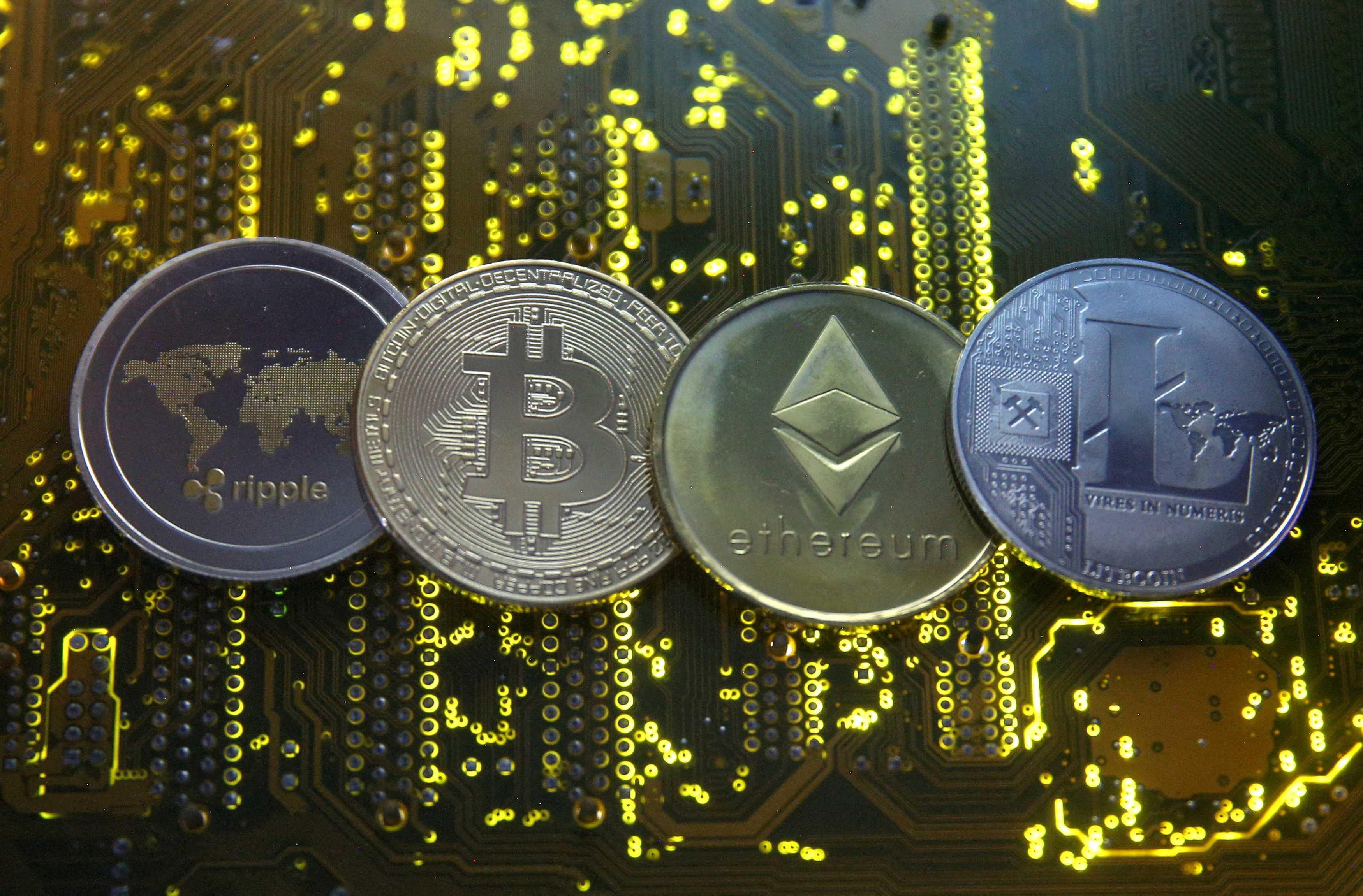 Representations of the Ripple, Bitcoin, Etherum and Litecoin virtual currencies are seen on a PC motherboard in this illustration picture, Feb 14, 2018. Photo: Reuters