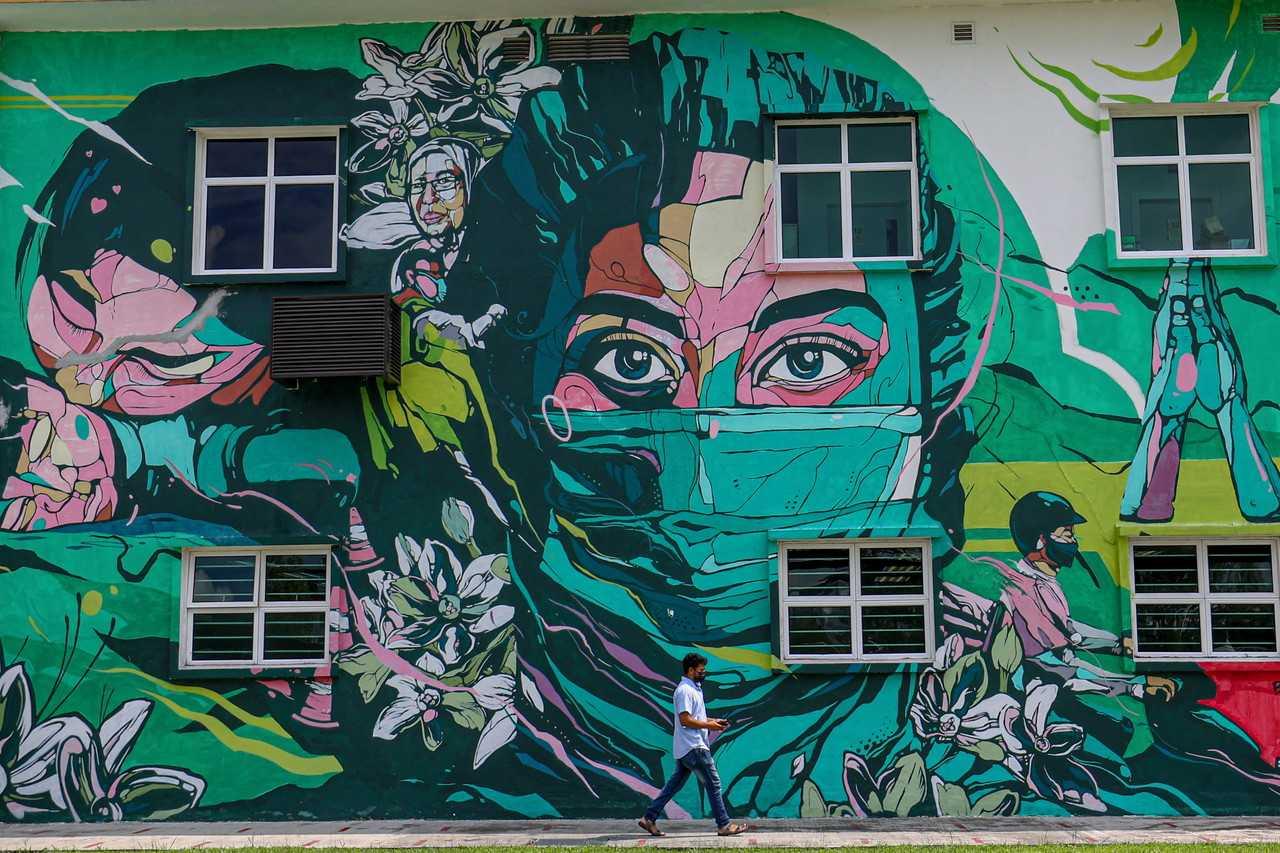 A man walks past a mural dedicated to frontliners at the Kuala Lumpur health clinic in the capital city. Photo: Bernama