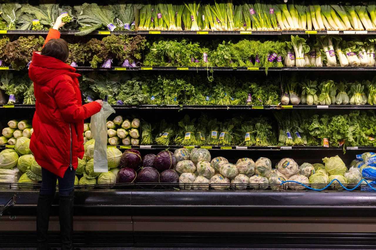 A woman shops for vegetables at a supermarket in Manhattan, New York City, March 28, 2022. Photo: Reuters