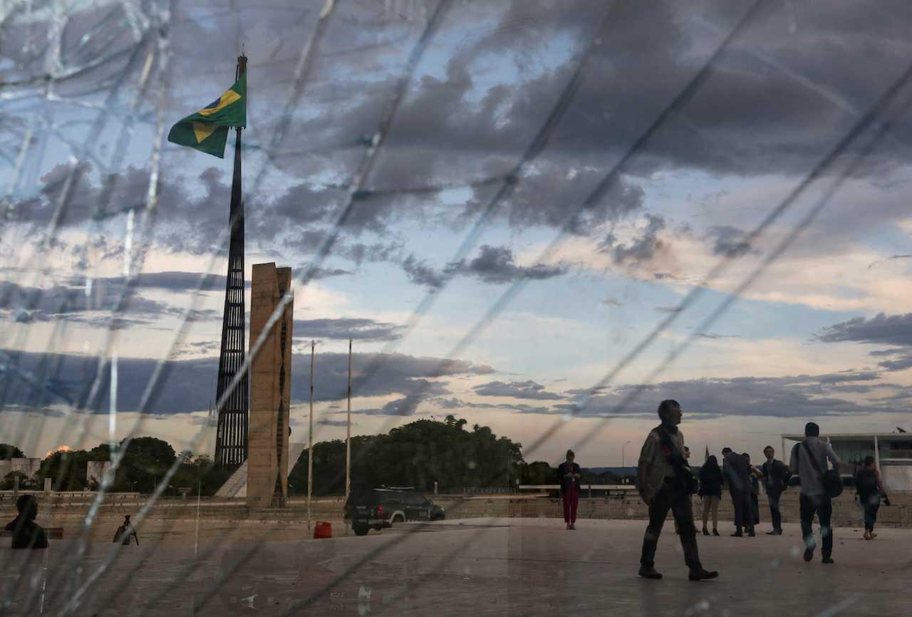 A Brazilian flag waves as seen behind broken glass at the Supreme Court building, following Brazil's riots, in Brasilia, Brazil, Jan 10. Photo: Reuters