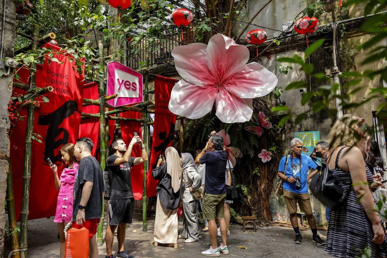 Visitors take pictures amid the Chinese New Year decorations at Lorong Kwai Chai Hong in Kuala Lumpur. Photo: Bernama