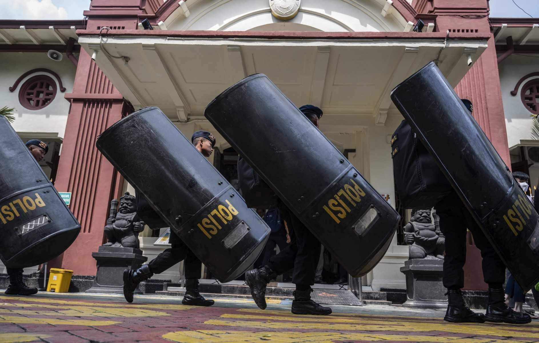 Police take up position outside the Surabaya courthouse ahead of the first trial of the Kajuruhan stadium stampede in Surabaya on Jan 16. Photo: AFP