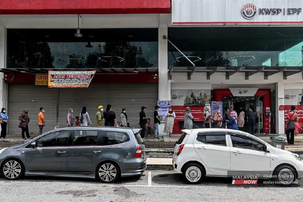 People line up in front of an EPF branch in Bandar Baru Nilai, Negeri Sembilan, following the government's announcement during the pandemic that contributors would be allowed to withdraw funds from their Account 1. 
