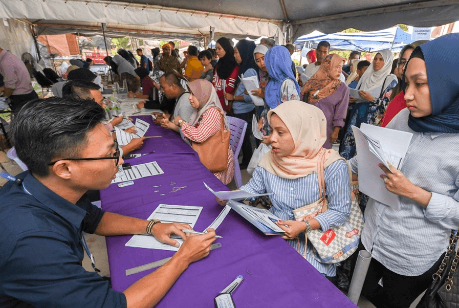 People queue to check their eligibility for Bantuan Sara Hidup payments at an Inland Revenue Board office in 2019. Photo: Bernama
