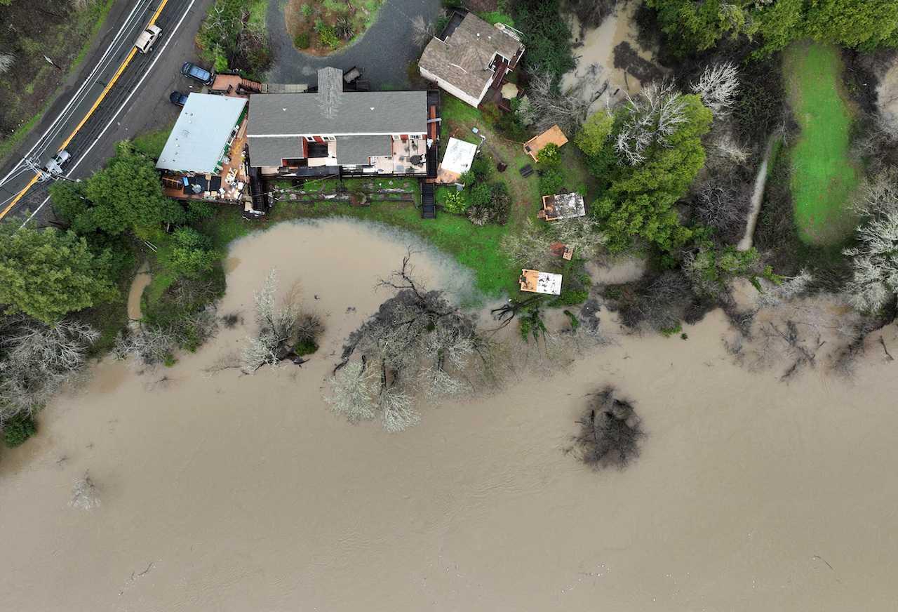 Floodwater from the Russian River approaches homes following a chain of winter storms, in Guerneville, California, Jan 15. Photo: Reuters