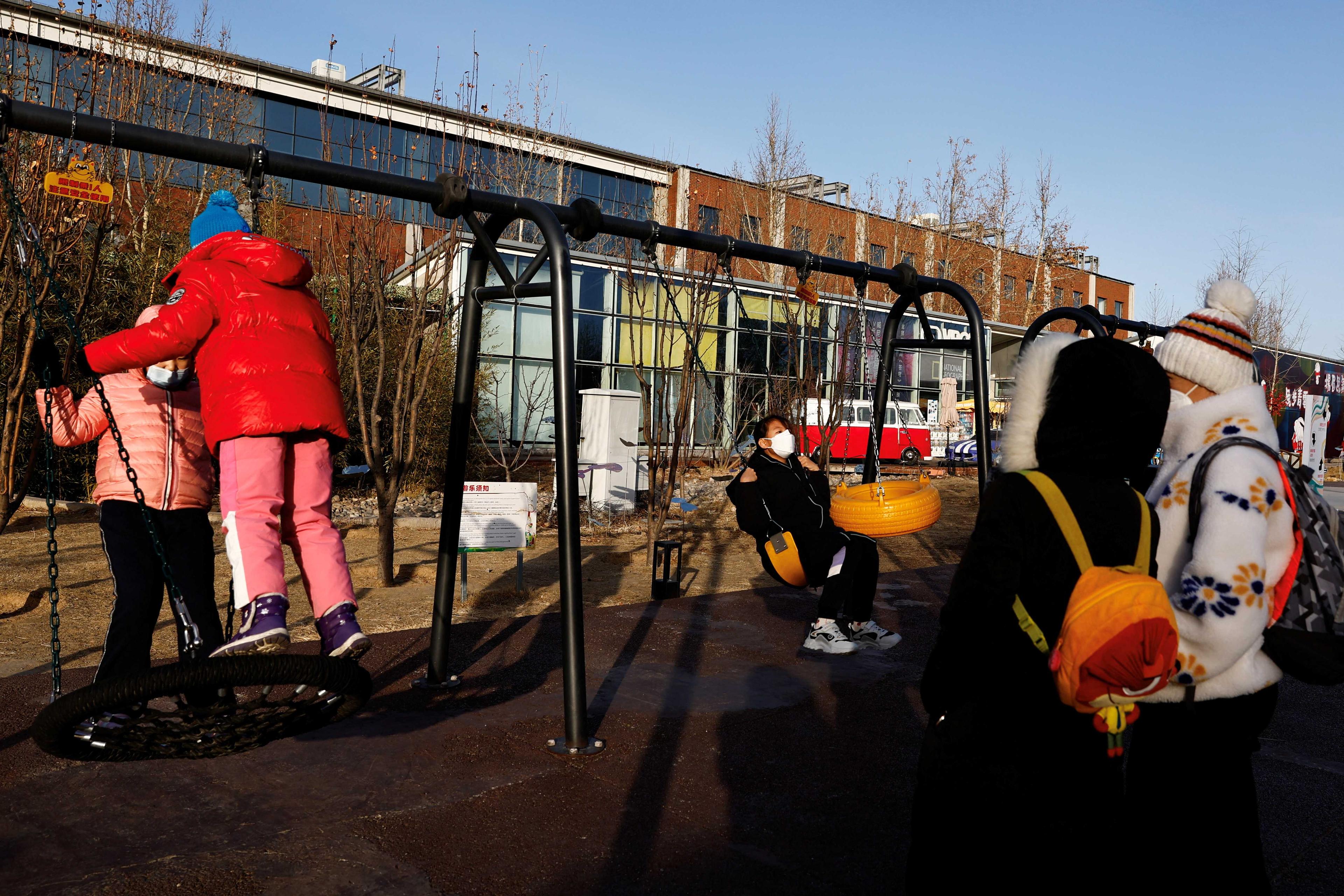 Children play on swings at an outdoor playground in Beijing, China Jan 14. Photo: Reuters