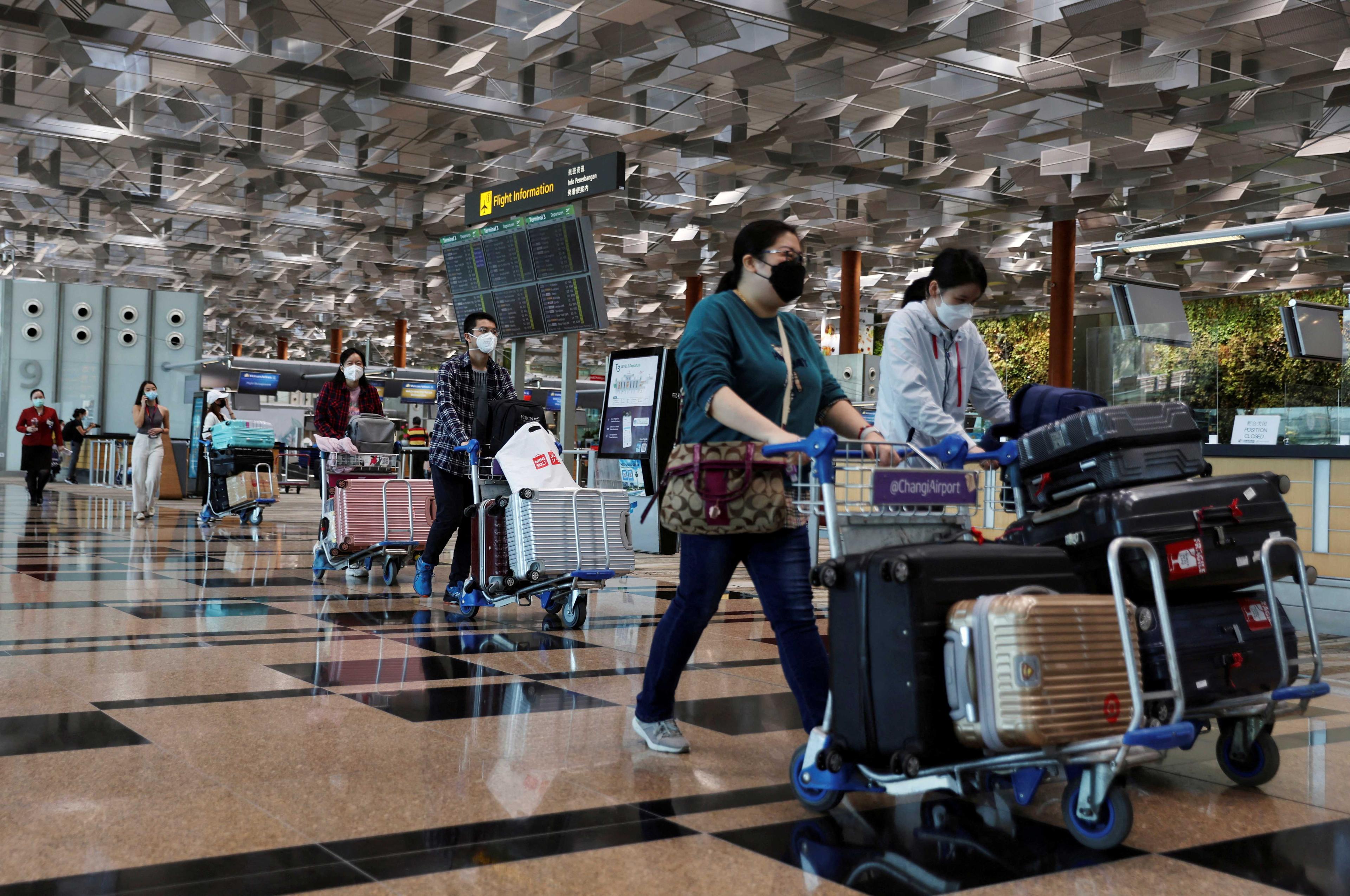 Travellers walk with their luggage at the Changi Airport in Singapore March 30, 2022.  Photo: Reuters