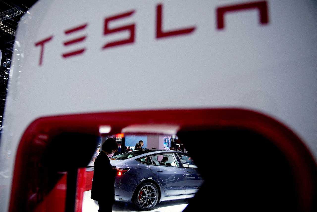 A Tesla electric vehicle is seen through a charging point displayed during a media day for the Auto Shanghai show in Shanghai, China, April 20, 2021. Photo: Reuters