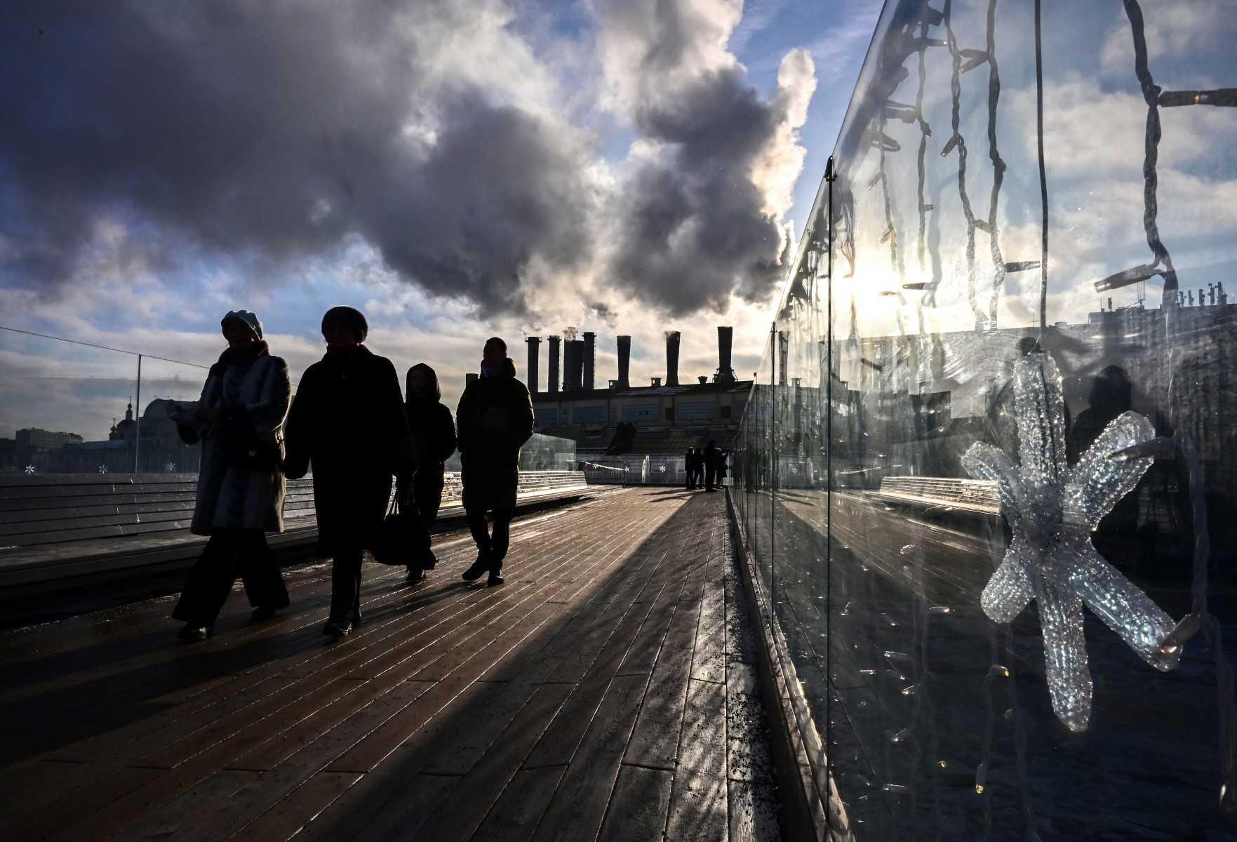 People visit the Zaryadye park as steam rises from chimneys of a heating power plant in central Moscow on Jan 12. Photo: AFP