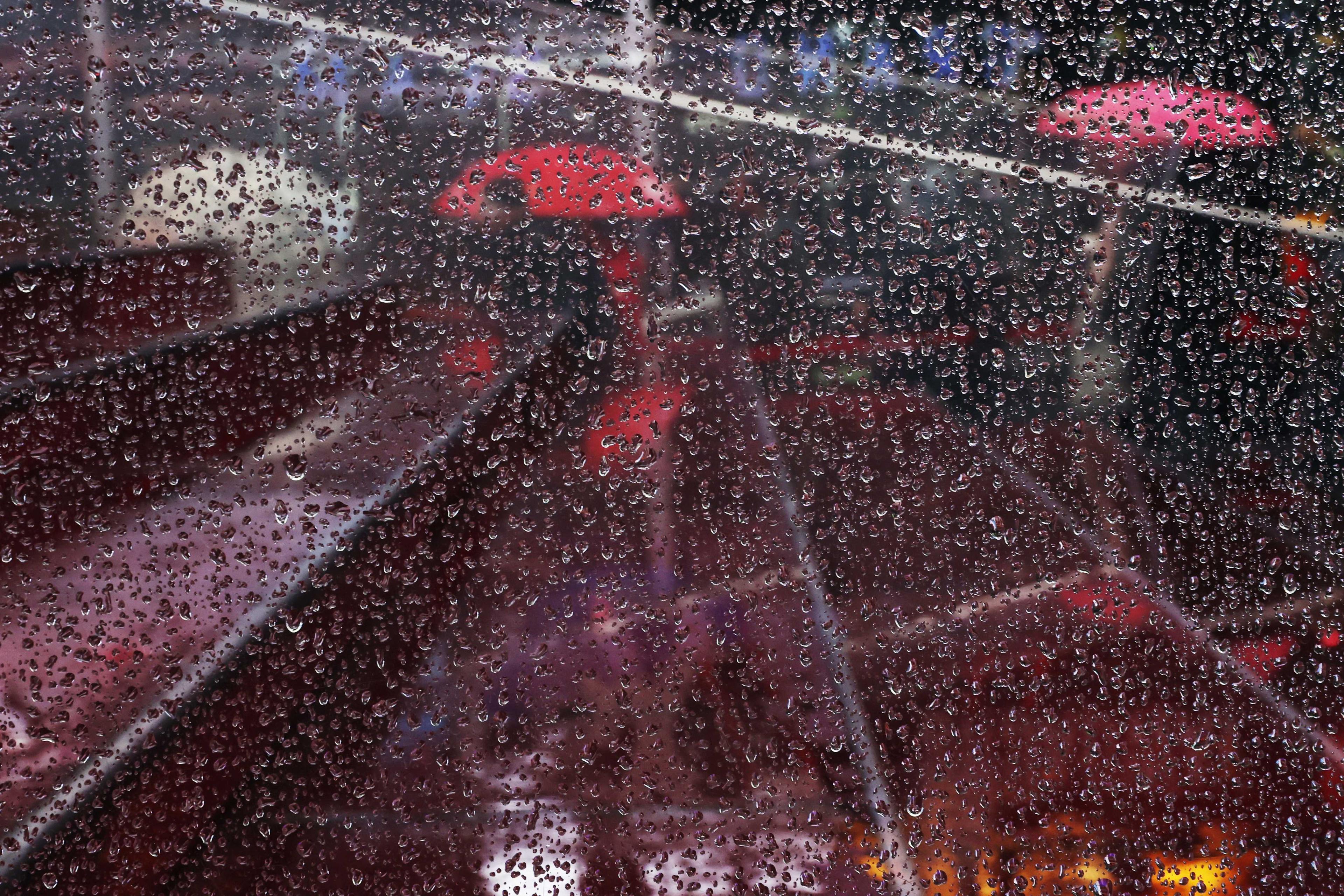 People are seen through rain drops waiting in line with umbrellas during rain in the Times Square section of New York City, US, Jan 19. Photo: Reuters