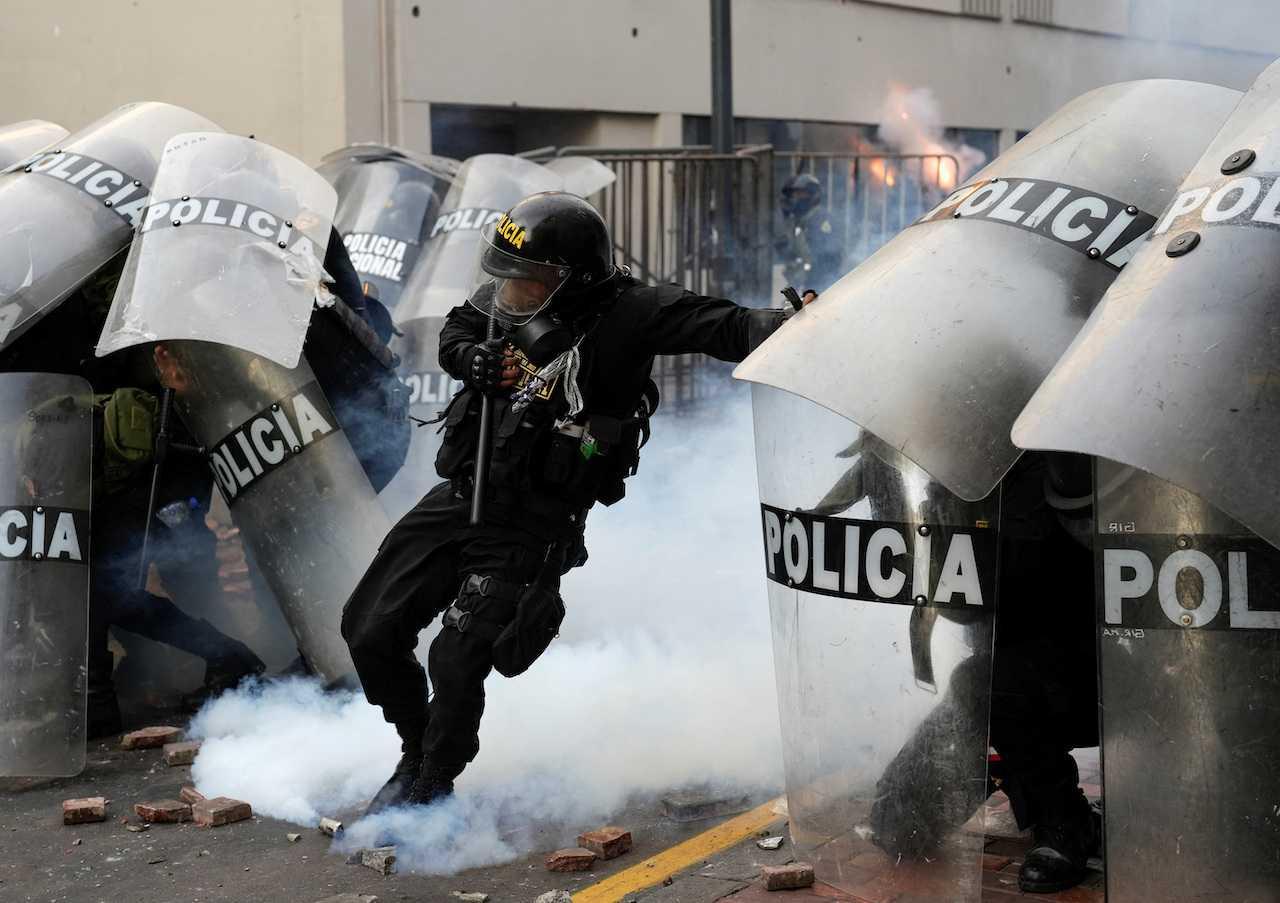 A riot police officer kicks a tear gas grenade during a march to demonstrate against Peru's President Dina Boluarte, following the ousting and arrest of former president Pedro Castillo, in Lima, Peru, Jan 19. Photo: Reuters