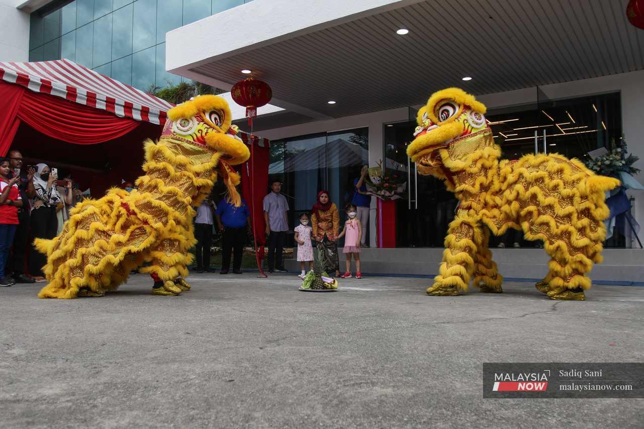 Outside, two golden lions perform at the entrance of the office building. 