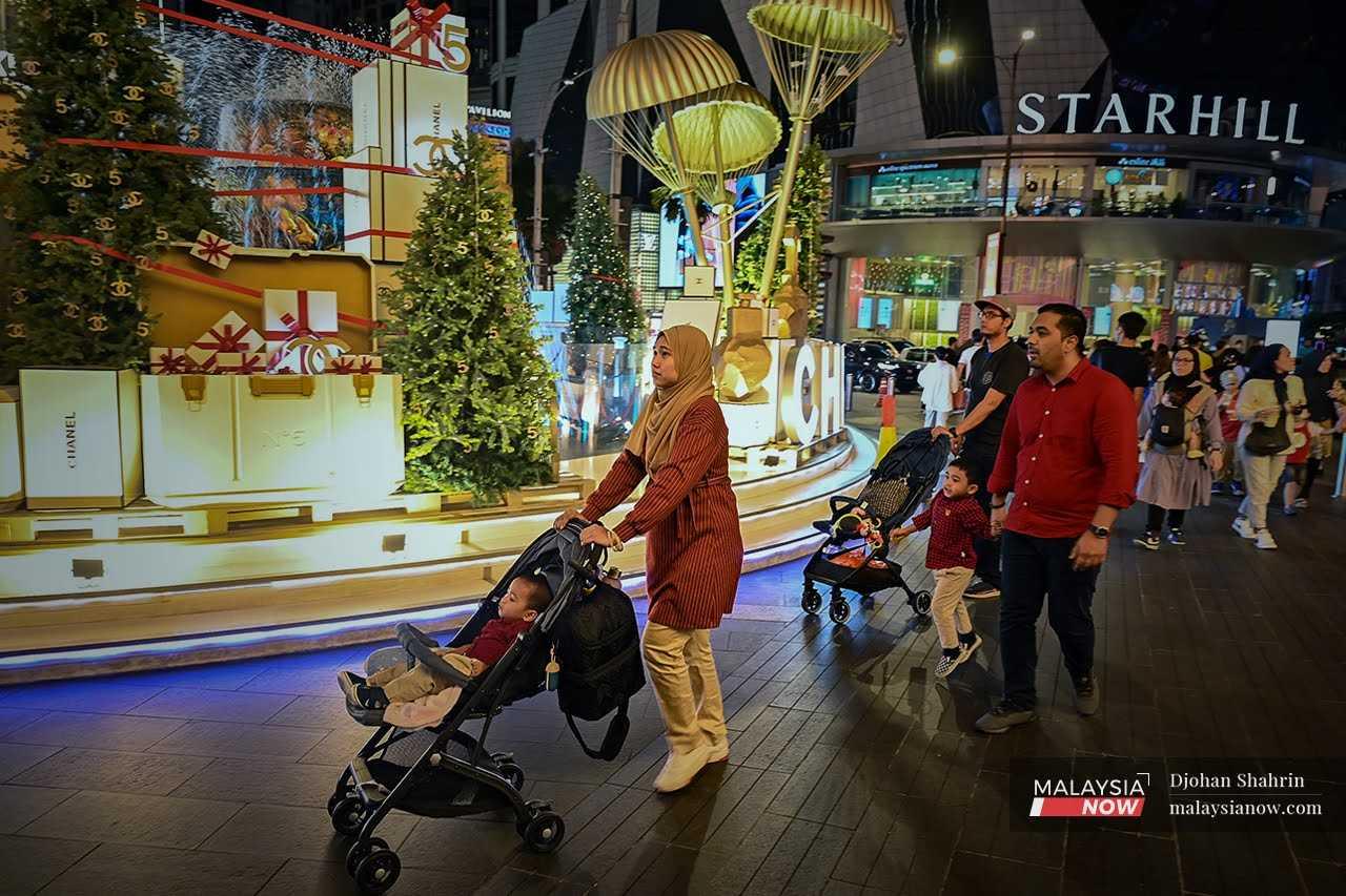 Orang ramai berjalan di sekitar foyer salah sebuah pusat membeli belah di Bukit Jalil, 21 Disember 2022.