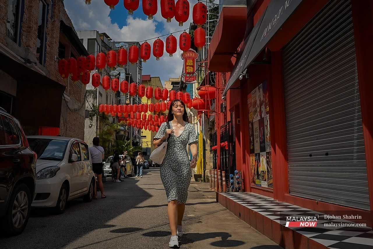 Physiotherapist and fitness trainer Regine Wong enjoys the Chinese New Year decorations at Petaling Street in Kuala Lumpur. 
