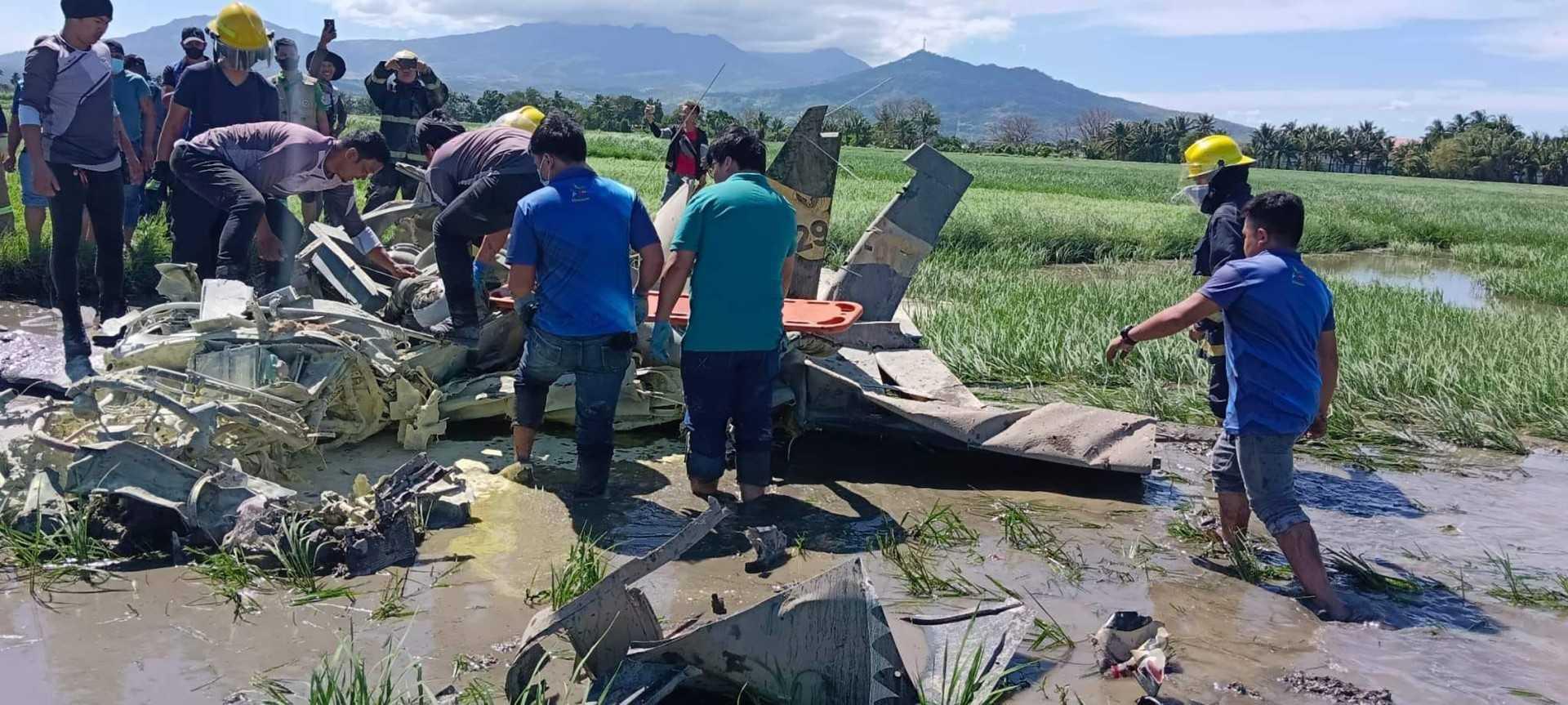 A handout photo from the Bureau of Fire Protection Region II taken and released on Jan 25 shows rescuers retrieving a body from a crashed plane in Pilar, Bataan, where two Philippine air force aviators were killed. Photo: AFP