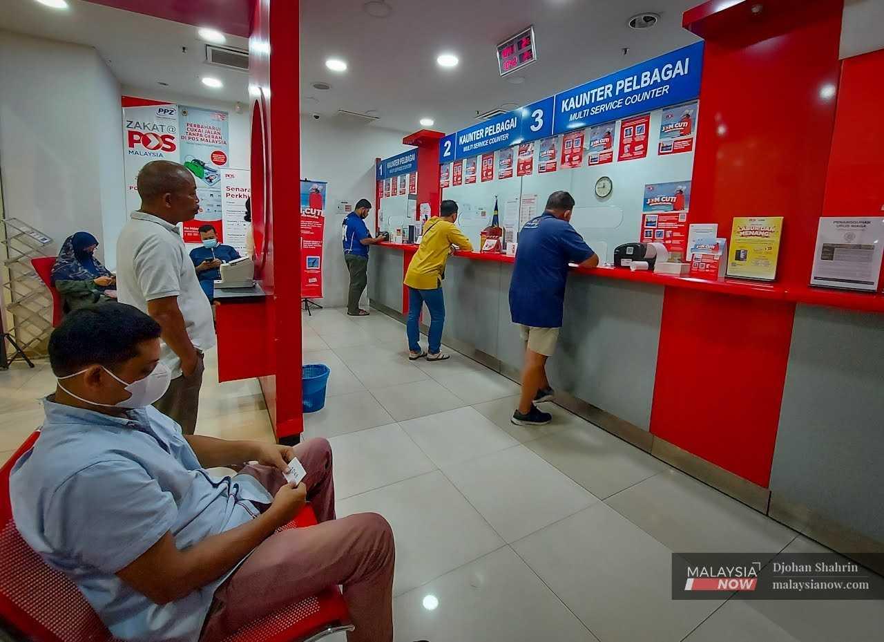 Beberapa pelanggan yang berurusan di kaunter pejabat Pos Malaysia di Taman Dagang, Ampang masih memakai pelitup muka sebagai satu langkah pencegahan bagi mengelakkan penularan virus Covid-19, 19 Disember 2022.