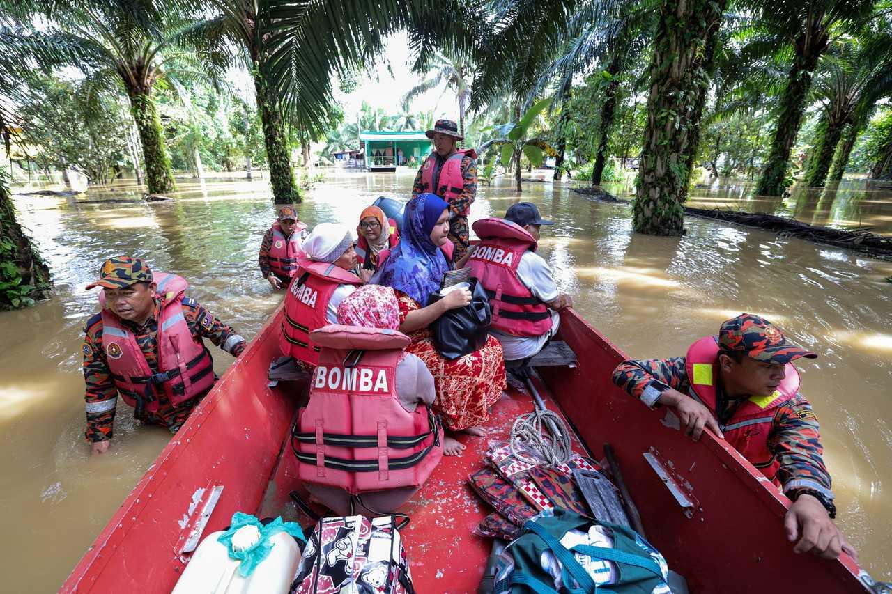 Search and rescue personnel evacuate residents at Kampung Rancangan Cocos, Pamol in Paitan. Photo: Bernama