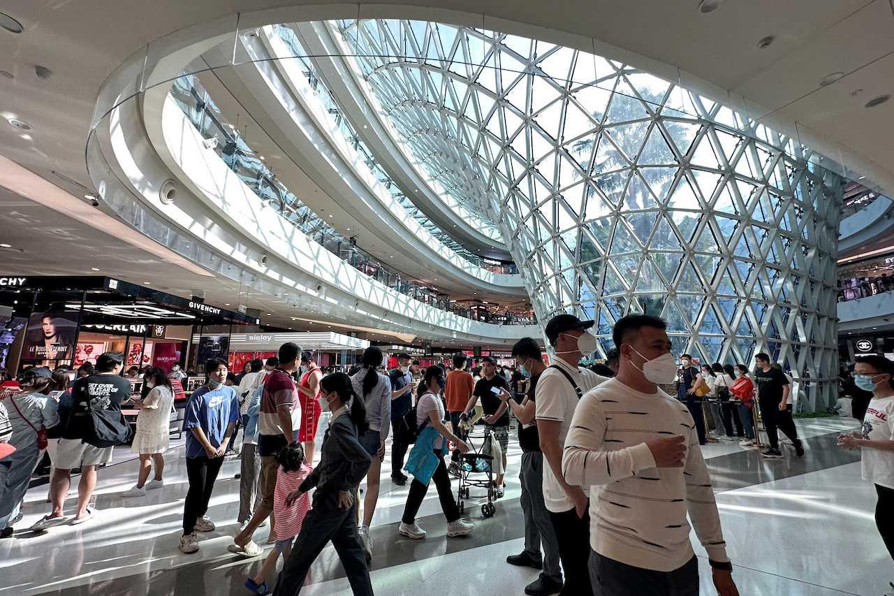People wearing face masks walk in the Sanya International Duty-Free shopping complex in Sanya, Hainan province, China, Jan 25. Photo: Reuters