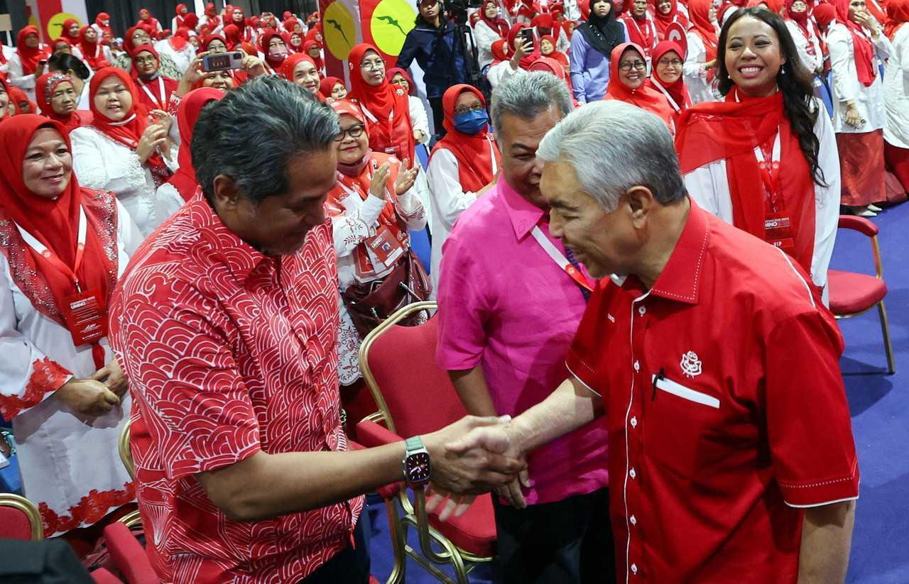 Khairy Jamaluddin (kiri) bersalaman dengan Presiden Umno Ahmad Zahid Hamidi pada Perhimpunan Agung Umno 2022 di Pusat Dagangan Dunia Kuala Lumpur, 12 Januari. Gambar: Bernama