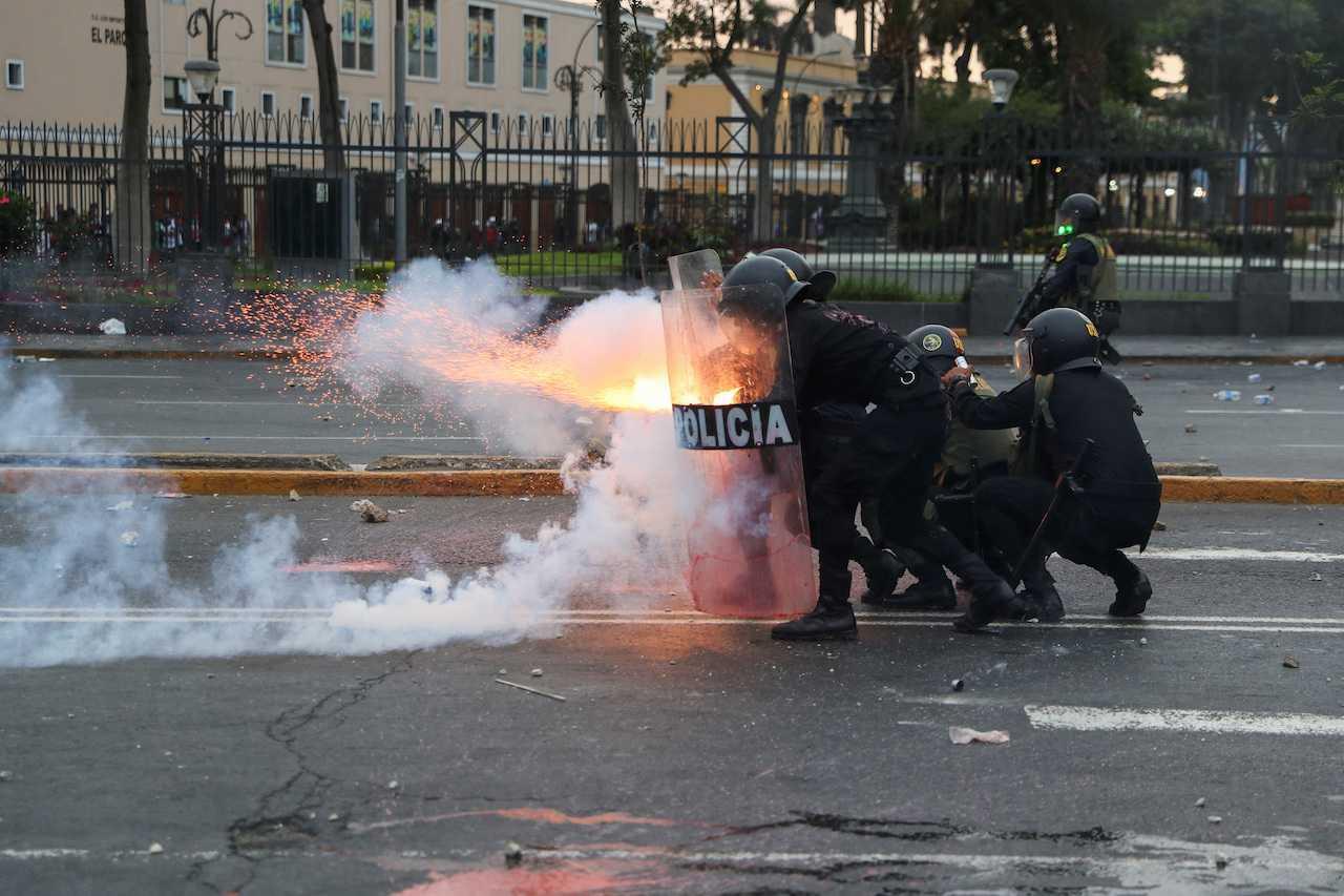 A riot police officer fires a weapon as demonstrators take part in a protest to demand that Peru's President Dina Boluarte step down, in Lima, Peru, Jan 28. Photo: Reuters
