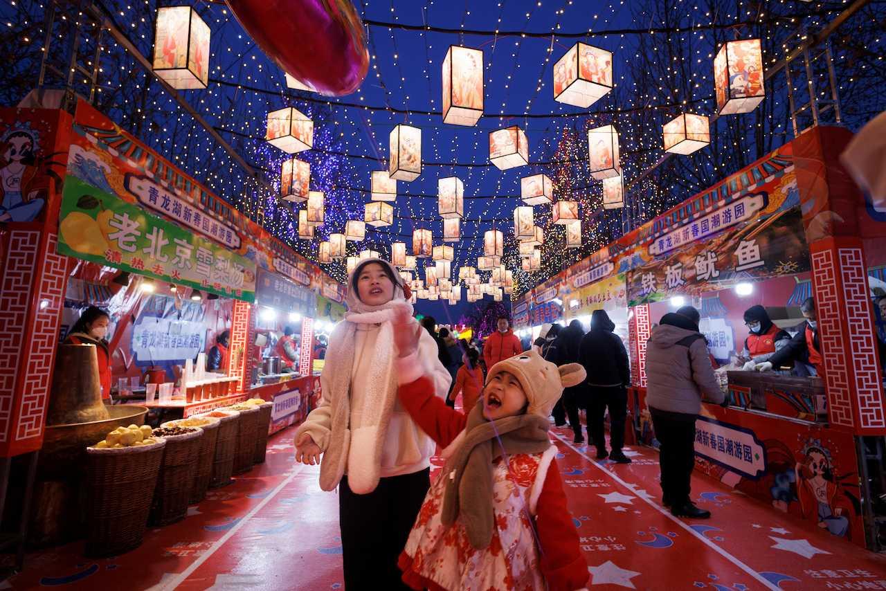 People walk through a decorated food court that is part of a Spring Festival light installation ahead of Chinese New Year in Qinglonghu Park in Beijing, Jan 21. Photo: Reuters