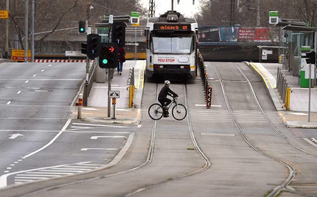 A person crosses an empty street in Melbourne on Aug 27, 2021. Photo: AFP
