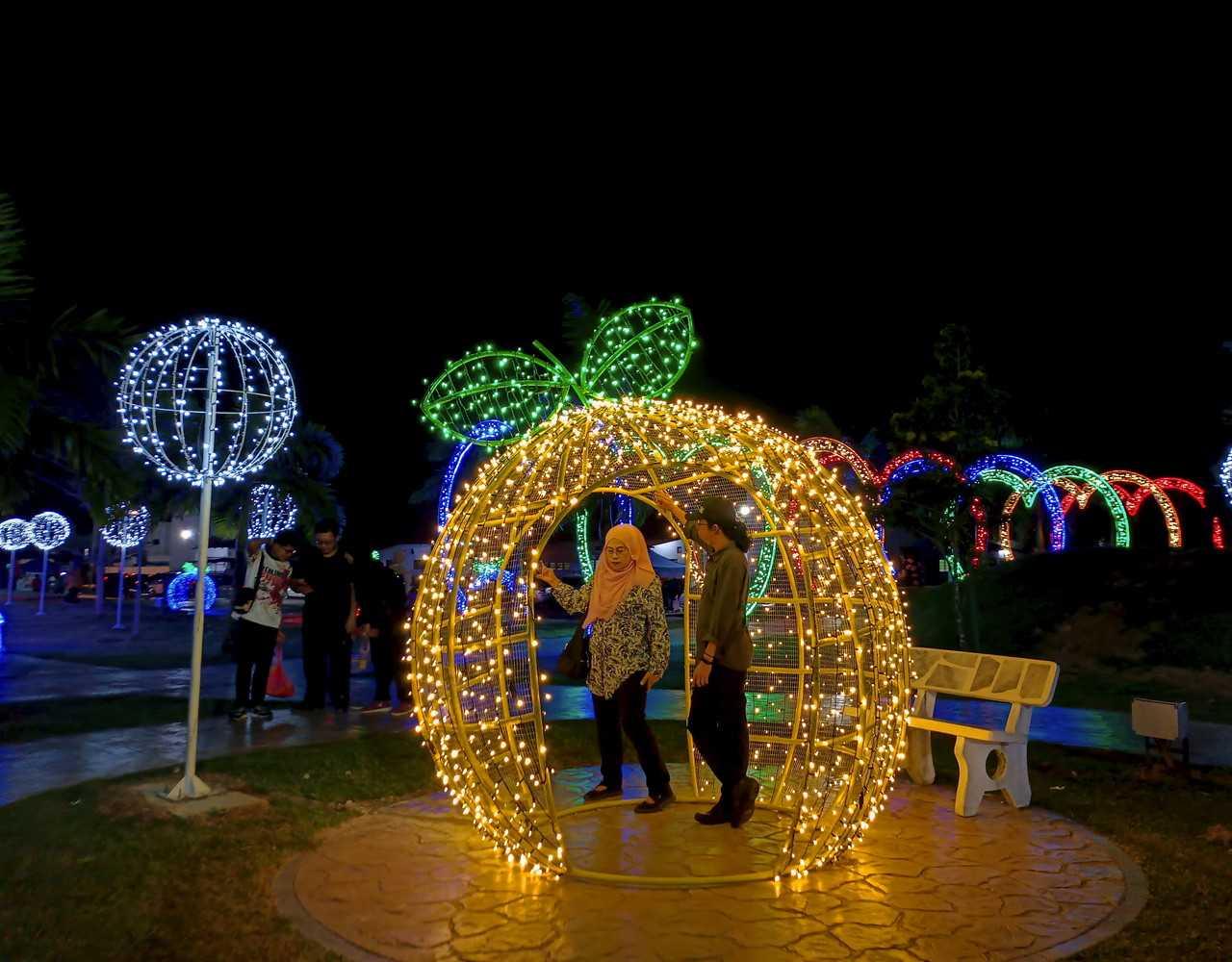 Visitors admire the lights and decorations at Laman Orang Kampung in Merlimau, Jasin. Photo: Bernama