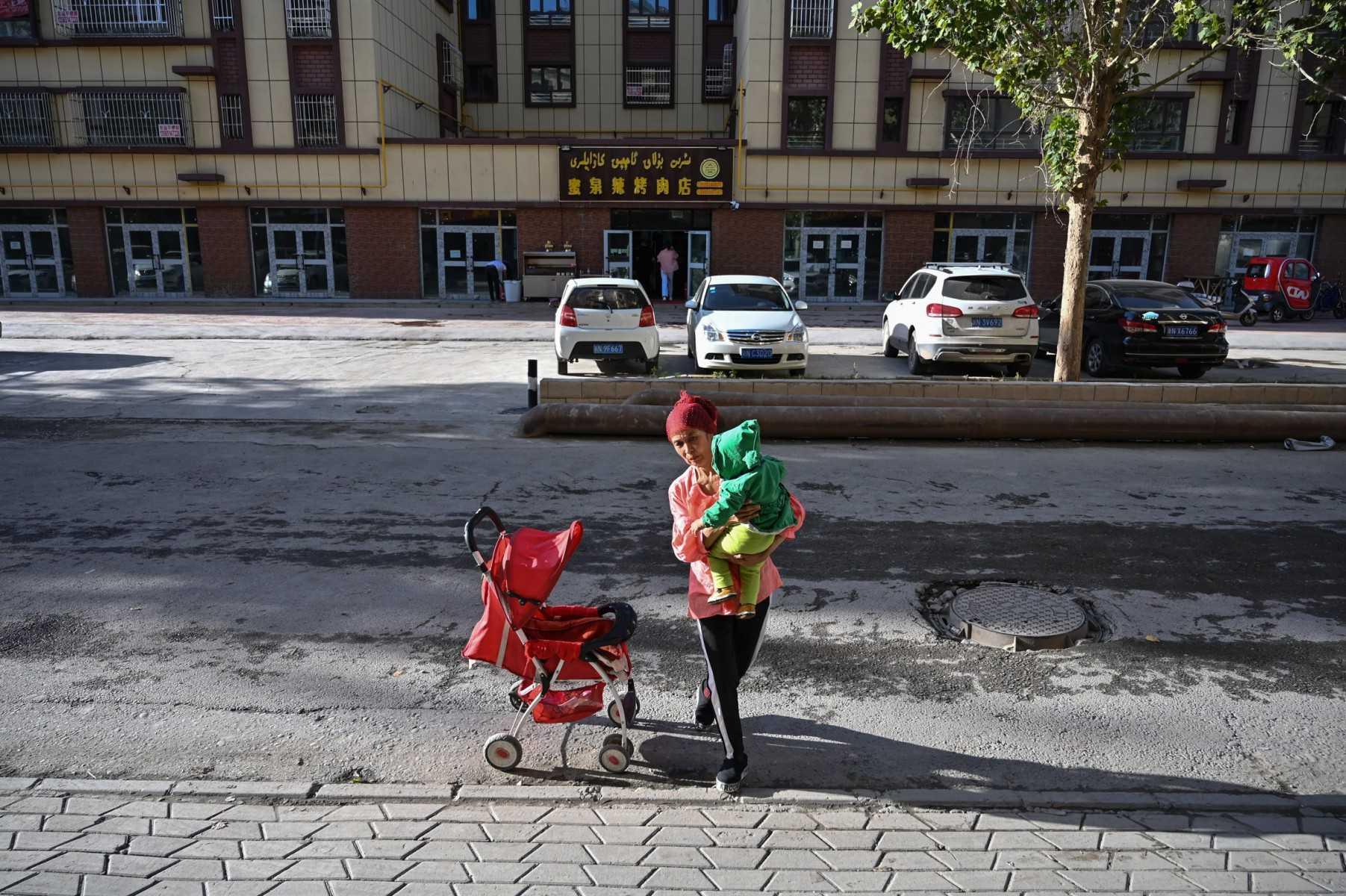This photo taken on Sept 11, 2019 shows a woman walking in an ethnic Uighur neighbourhood in Aksu in the region of Xinjiang. Photo: AFP