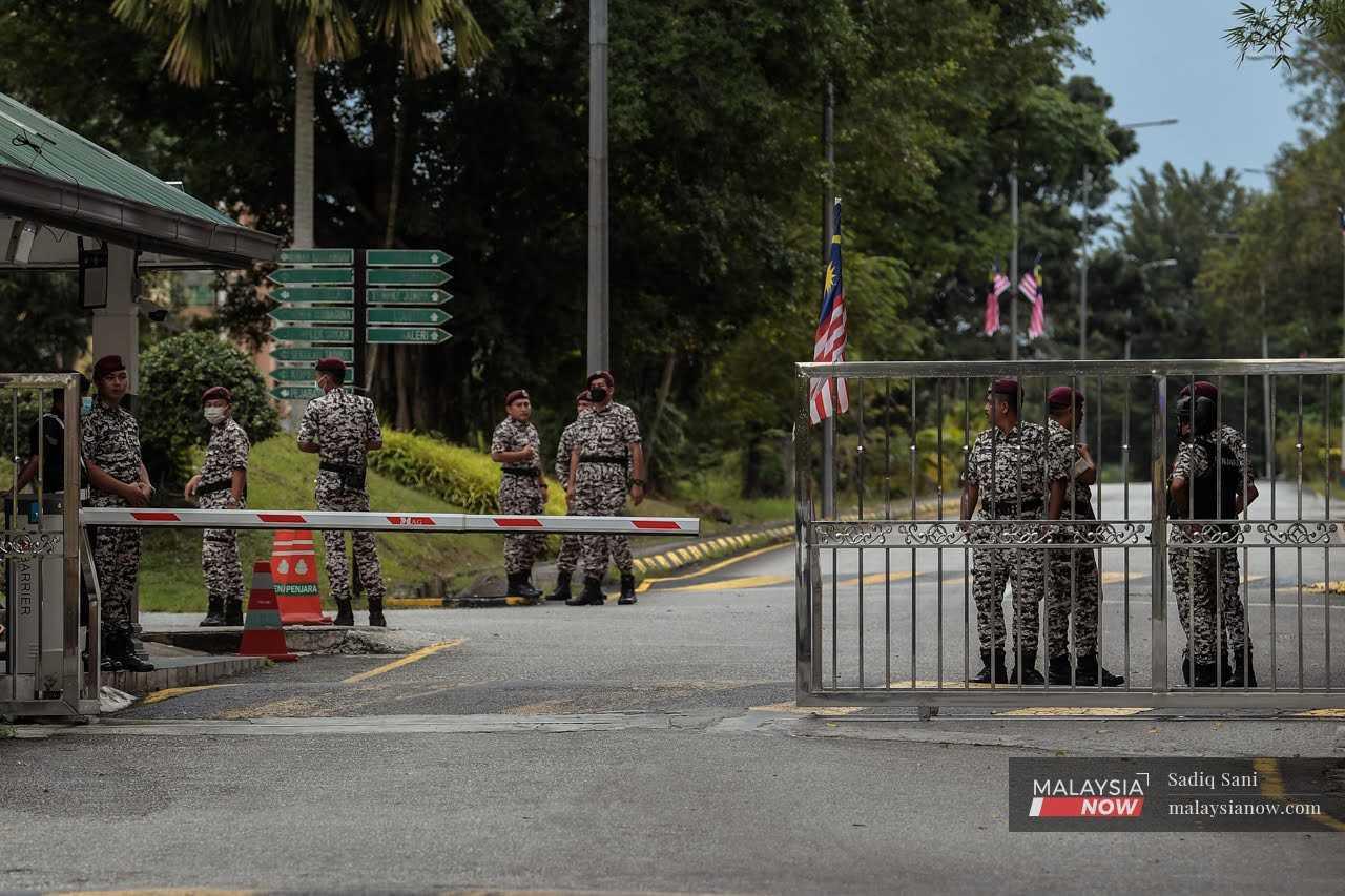 Prison officers stand at the entrance of Sungai Buloh Prison. 