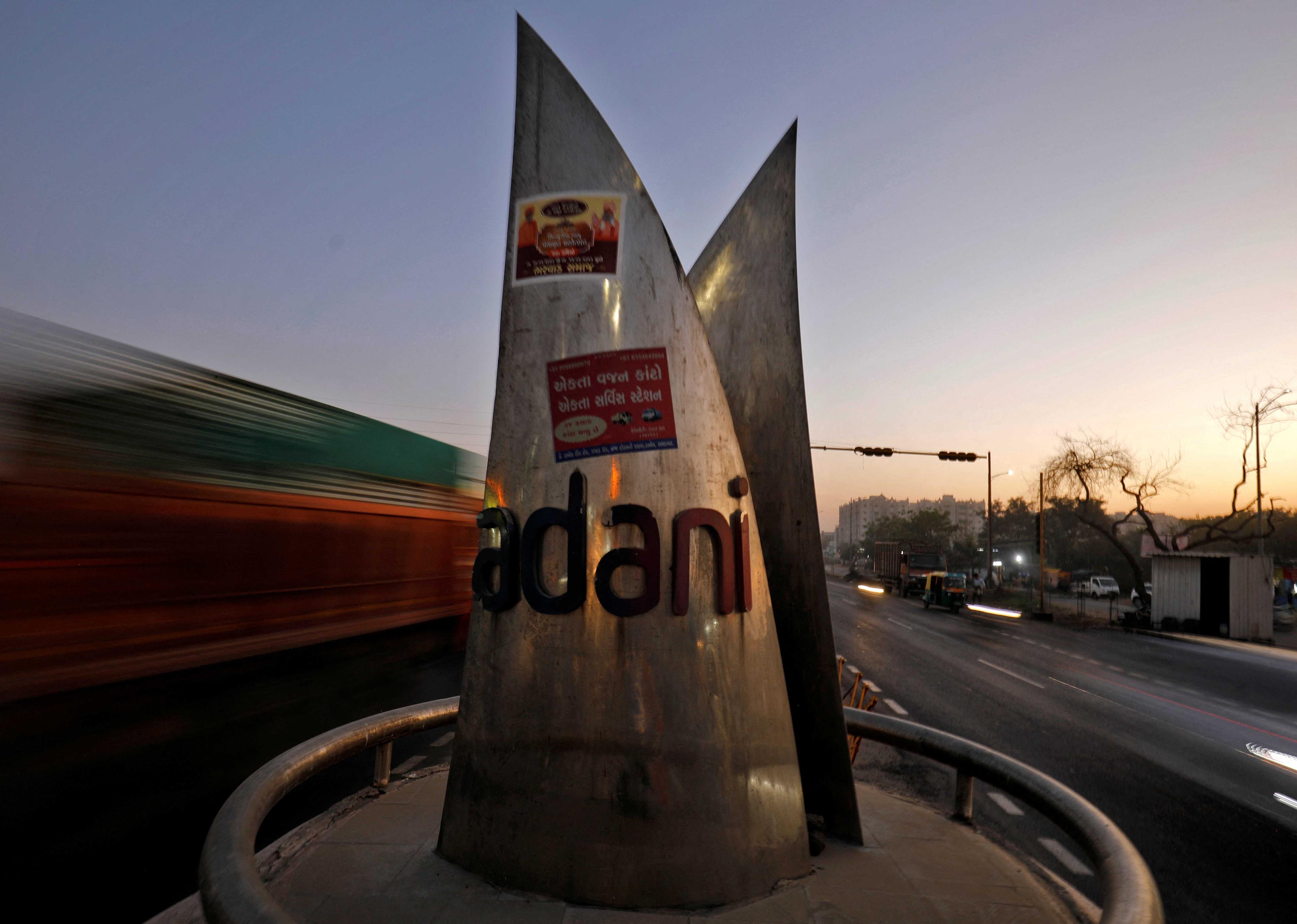 Traffic moves past the logo of the Adani Group installed at a roundabout on the ring road in Ahmedabad, India, Feb 2. Photo: Reuters