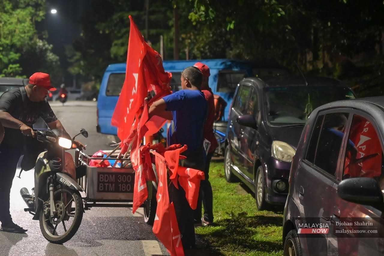 Party workers put up Pakatan Harapan flags in Taman Keramat Permai, Kuala Lumpur, ahead of the 15th general election on Nov 7, 2022. 
