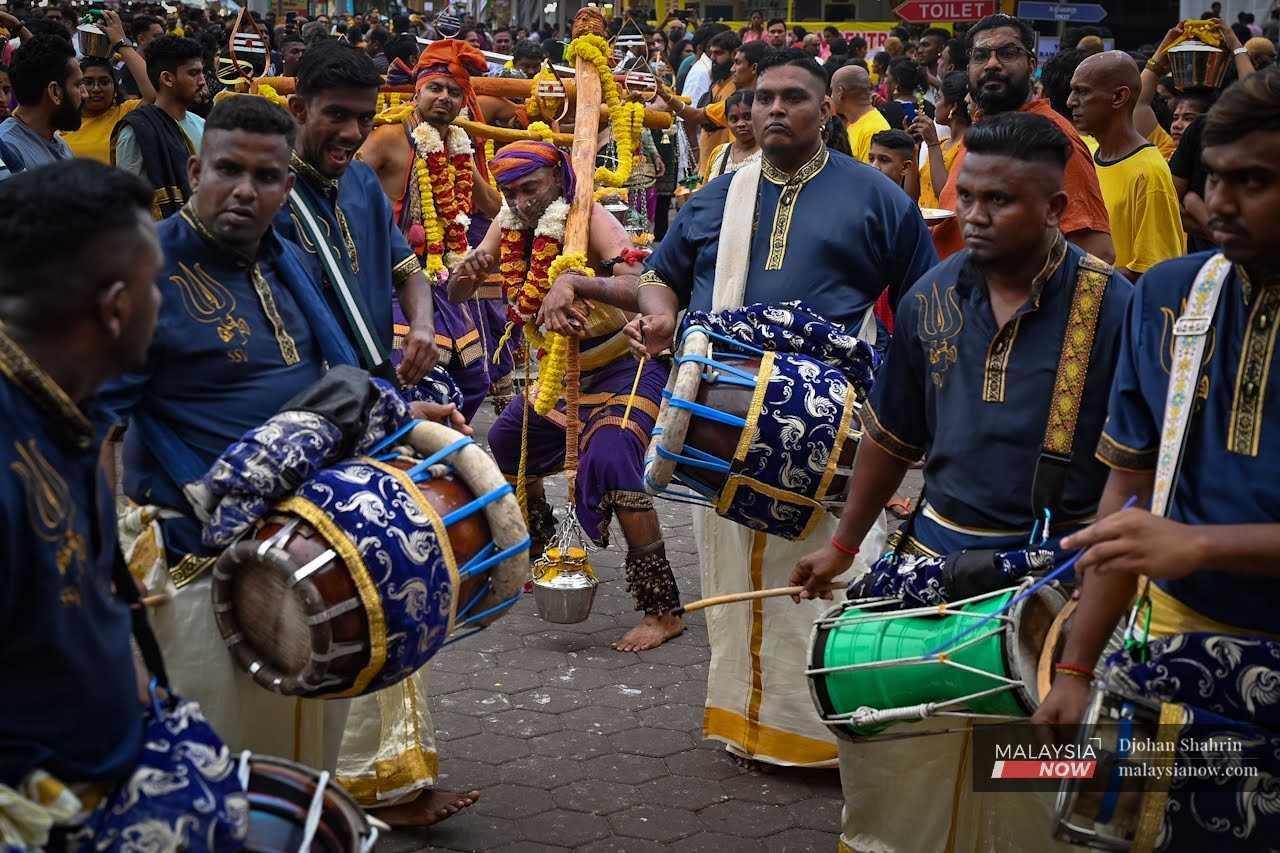 Devotees play drums during a religious procession at the temple in Batu Caves. 
