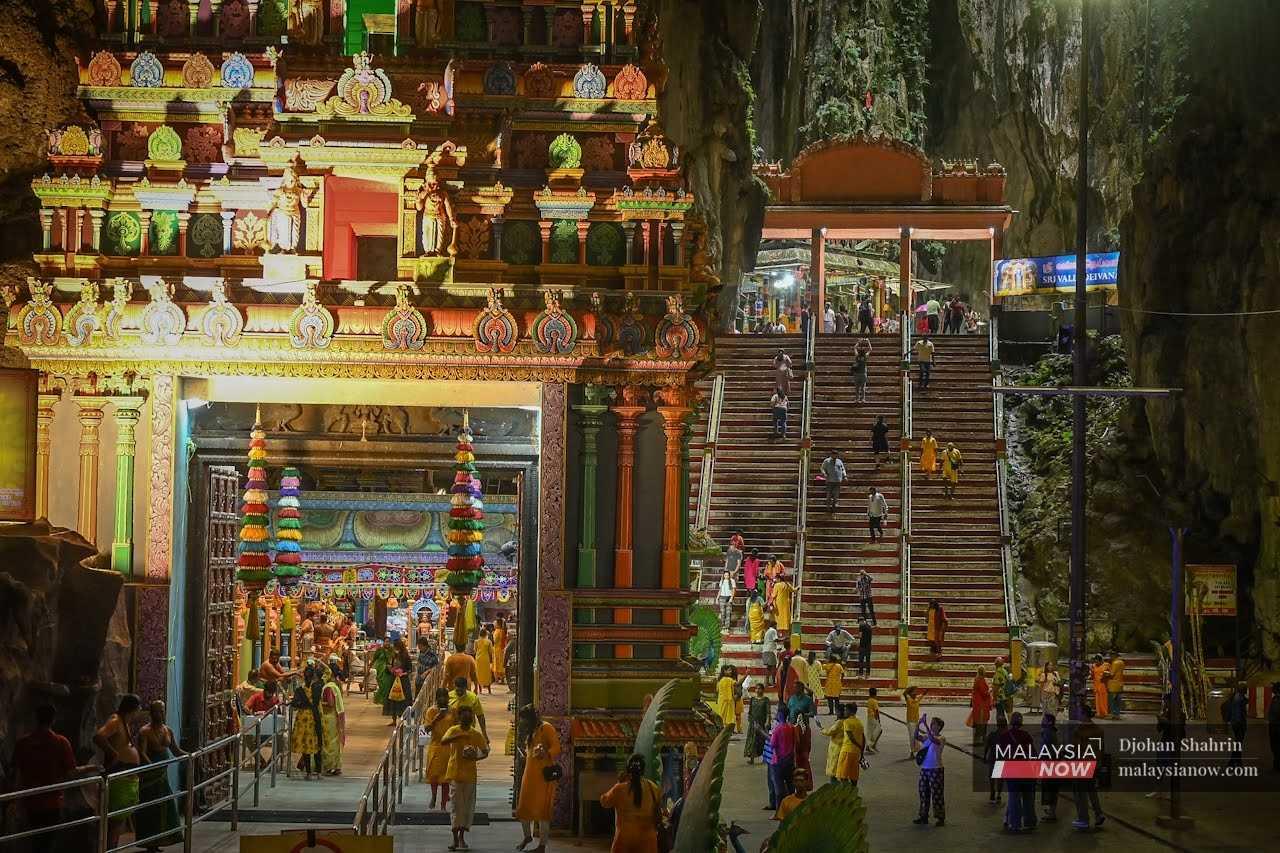 Penganut Hindu memenuhi kuil, yang dipenuhi cahaya dan warna.