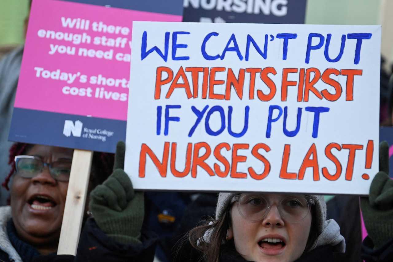 NHS nurses hold banners during a strike, amid a dispute with the government over pay, in London, Britain, Jan 18. Photo: Reuters