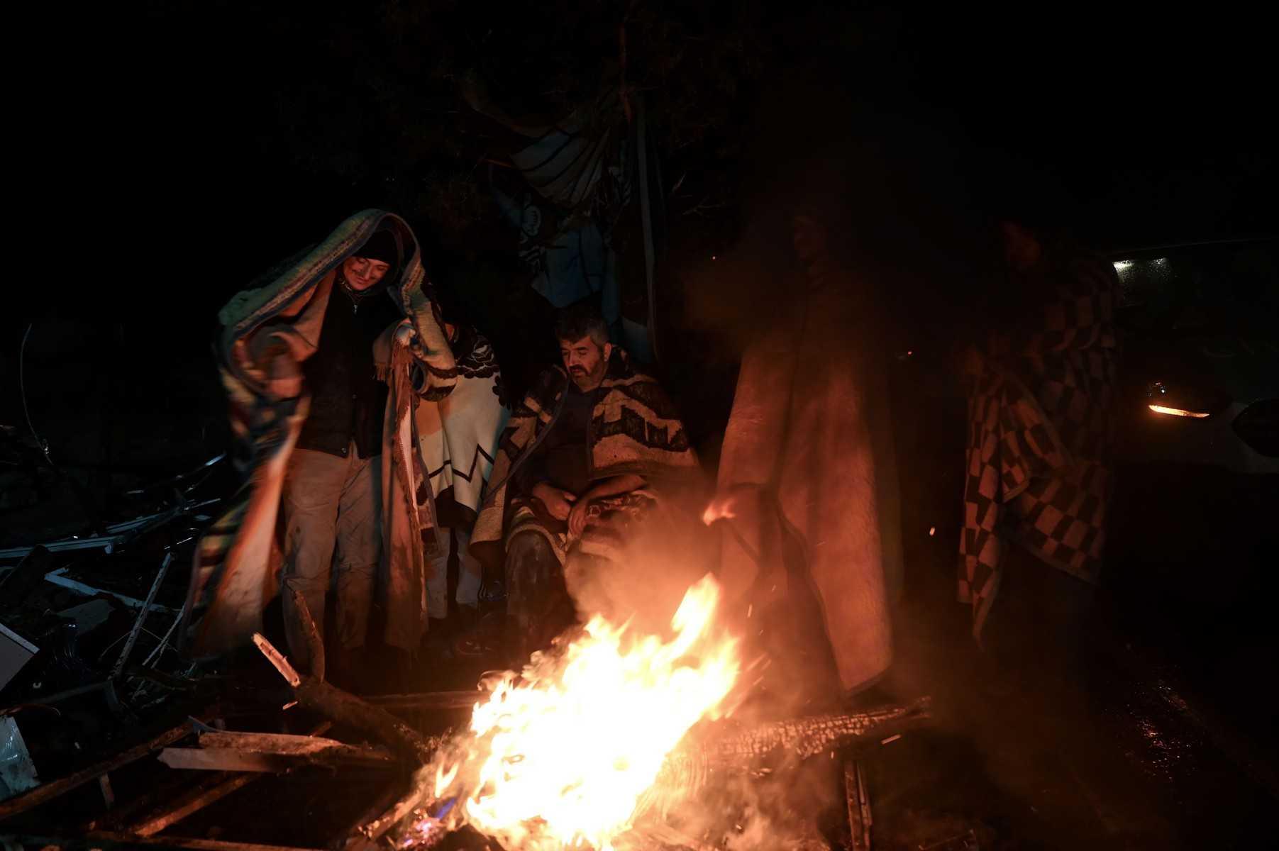 People warm themselves around a bonfire in the rubble in Kahramanmaras, Turkey, after a 7.8-magnitude earthquake struck the country's southeast on Feb 7. Photo: AFP