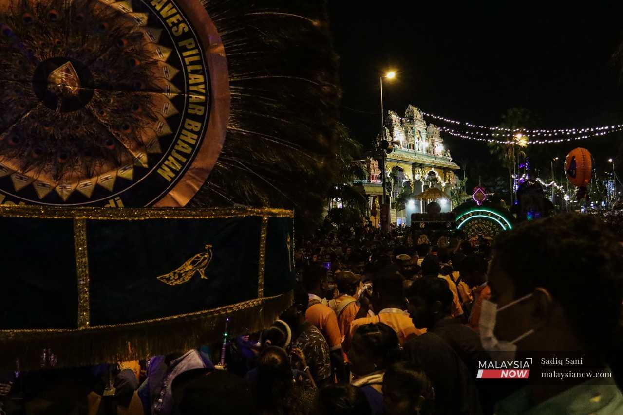 The procession nears the entrance of the temple in Batu Caves as massive crowds gather at the gates. 
