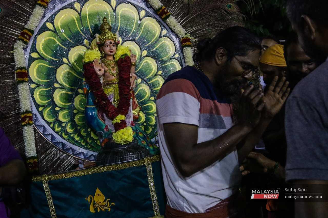 Sureshkumar Manogeran stands next to his kavadi, which he will carry on his shoulders during this year's Thaipusam procession.