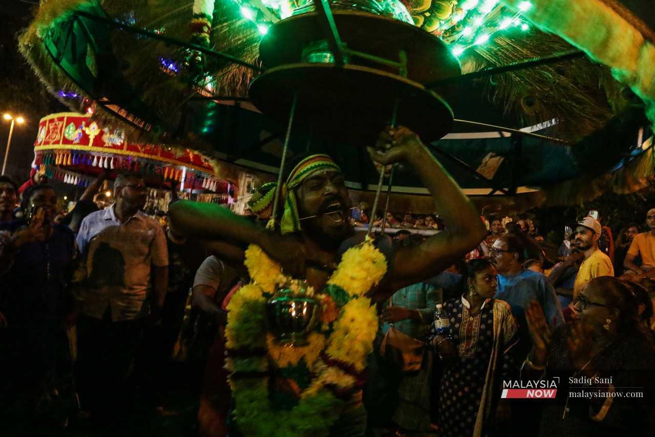 Suresh enters a trance as he dances with his kavadi. 
