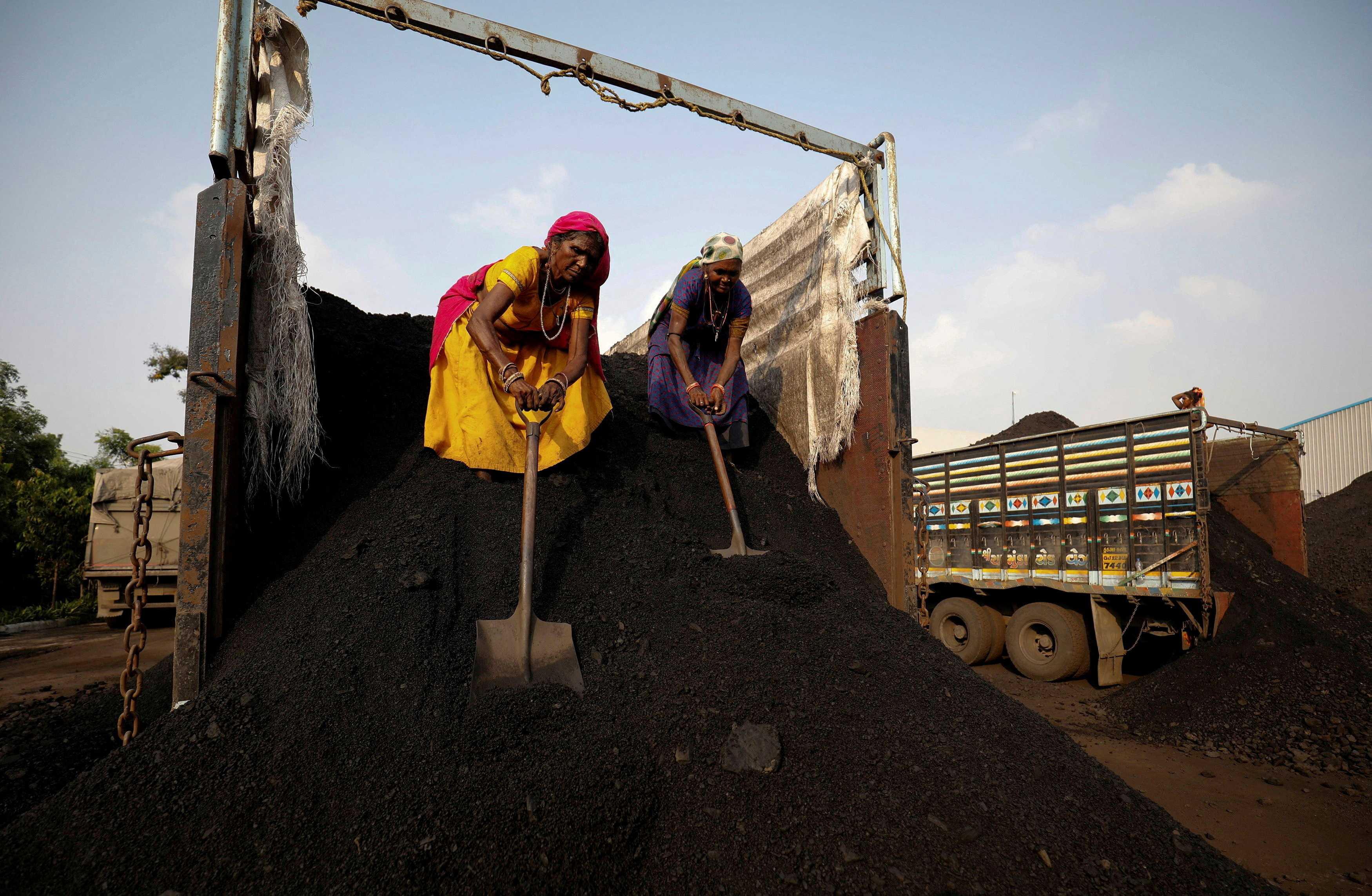 Workers unload coal from a supply truck at a yard on the outskirts of Ahmedabad, India, Oct 12, 2021. Photo: Reuters